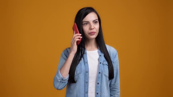 Дівчина викликала крик розбиття хлопця смартфон ізольований гірчичний кольоровий фон — стокове відео