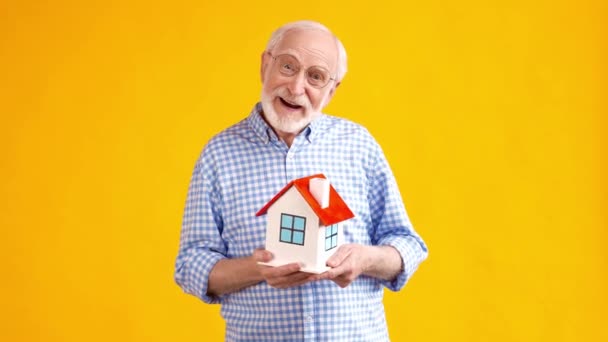 Interessierter Opa hält Hausfigur-Umzugskonzept — Stockvideo