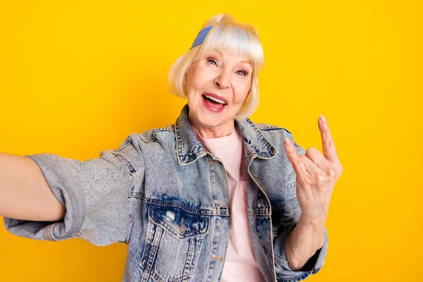 Zelfportret van oudere gepensioneerde gepensioneerde vrolijke vrouw tonen hoorn plezier geïsoleerd over helder gele kleur achtergrond — Stockfoto