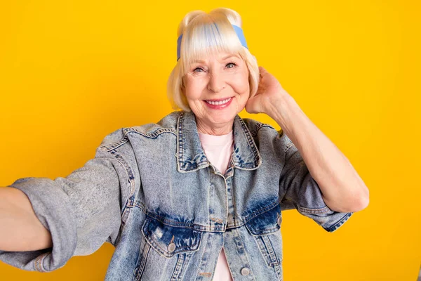 Foto portrét starší ženy usmívající se přičemž selfie ve stylovém oblečení izolované na jasně žlutém pozadí — Stock fotografie