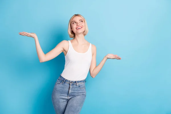 Photo of adorable satisfied lady raise arms palms look interested empty space isolated on blue color background — Stock Photo, Image