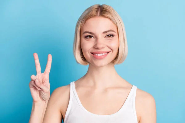 Fotografie šťastné veselá hezká mladá žena držet ruční show V-sign úsměv izolované pastel modrá barva pozadí — Stock fotografie