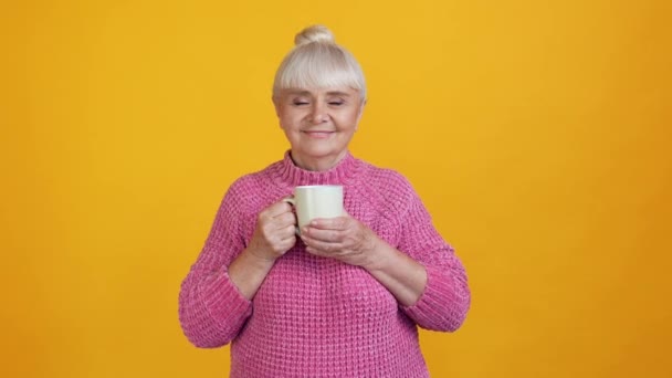 Inspired carefree grandma hold mug drink herbal tea smell aroma — Stock Video