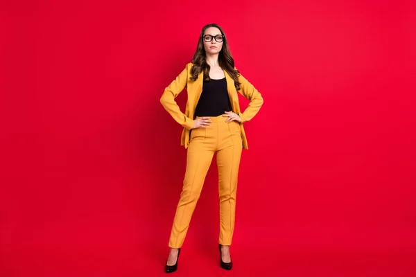 クールな自信のある若い女性の写真は黄色のブレザーメガネ腕腰隔離された赤の色の背景を身に着けて — ストック写真
