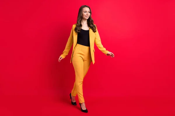 Largura completa de la foto de feliz encantadora mujer joven mirada ir vacío espacio sonrisa aislada en el fondo de color rojo — Foto de Stock