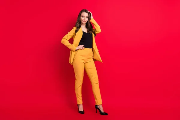 Foto de adorable mujer joven brillante usar chaqueta amarilla brazo cintura pelo sonriente aislado color rojo fondo — Foto de Stock