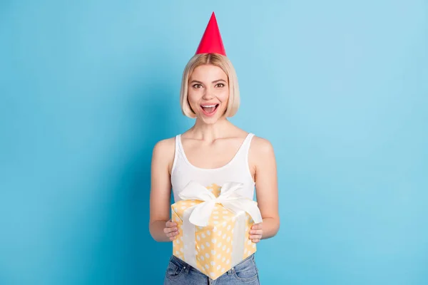 Portrét atraktivní veselá blond dívka drží v ruce dárkové krabice s zábavou izolované přes jasně modré barvy pozadí — Stock fotografie