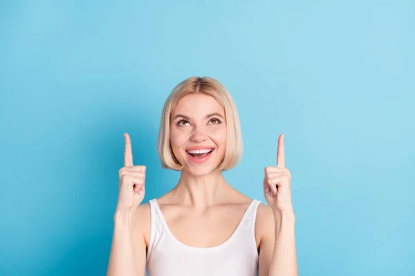 Portret van vrij positieve dame look geven vingers omhoog lege ruimte geïsoleerd op blauwe kleur achtergrond — Stockfoto