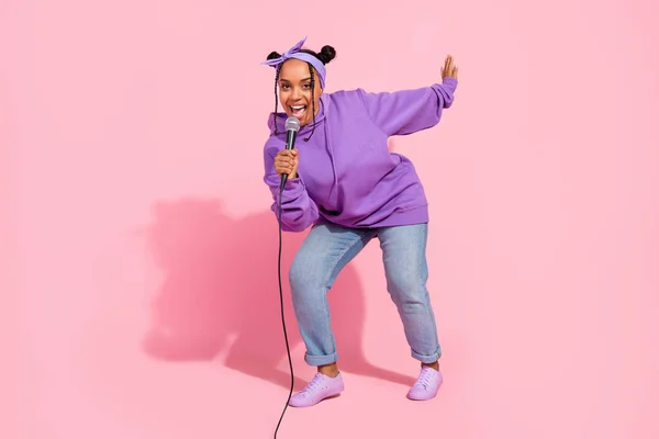 Photo de belle femme afro funky porter des petits pains à capuche violet danse karaoké souriant isolé fond de couleur rose — Photo