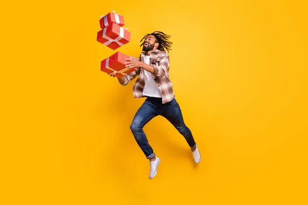 Volledige lichaamsomvang uitzicht van mooie vrolijke man springen gooien laten vallen giftboxen geïsoleerd over helder gele kleur achtergrond — Stockfoto