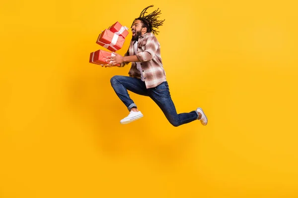 Tamanho total do corpo foto de homem pulando alto jogando no ar presentes caixas em feriados isolados no fundo de cor amarelo brilhante — Fotografia de Stock