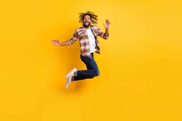 Tamanho total do corpo foto de homem pulando alto vestindo roupas casuais rindo isolado no fundo de cor amarelo vívido — Fotografia de Stock