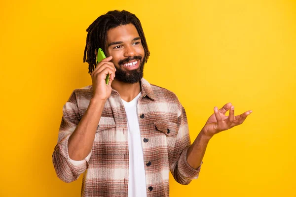 Foto portret van brunet man praten op mobiele telefoon op zoek naar copyspace geïsoleerd op levendige gele kleur achtergrond — Stockfoto