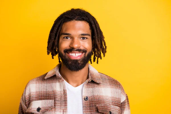 Foto van funky grappige donkere huid guy dragen geruite shirt glimlachen geïsoleerde gele kleur achtergrond — Stockfoto