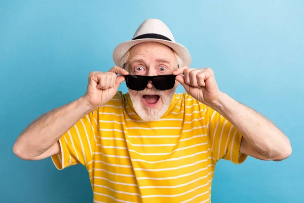 Retrato de agradable hombre de pelo gris alegre aturdido que se divierte tocando especificaciones aisladas sobre fondo de color azul brillante — Foto de Stock