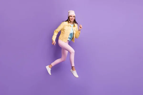 Фотографія повного розміру тіла молодої жінки, що стрибає швидко ізольовано на яскраво-фіолетовому кольоровому фоні — стокове фото
