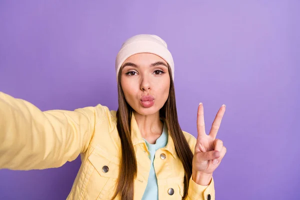 Φωτογραφία πορτρέτο του κοριτσιού λήψη selfie σε casual ρούχα στέλνοντας αέρα φιλί pouted χείλη v-σημάδι απομονώνονται σε παστέλ βιολετί χρώμα φόντο — Φωτογραφία Αρχείου