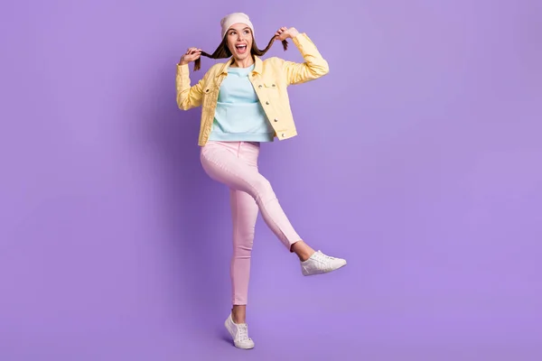 Фотографія повного розміру оптимістичного прямого волосся дівчина танцює піджак штани кросівки ізольовані на фіолетовому кольоровому фоні — стокове фото