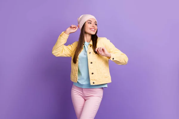 楽観的なストレートヘアドアの女の子のダンスは、紫の色の背景に隔離されたキャップジャケットを着用 — ストック写真