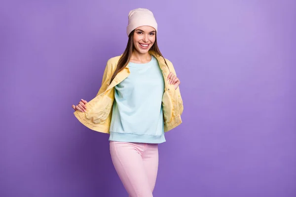 楽観的なストレートヘアドアの女の子の写真は、服が紫色の背景に隔離されたキャップジャケットを着用示しています — ストック写真