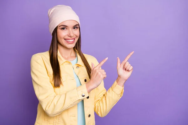 Portret optymistycznej prostej fryzura dziewczyna punkt puste miejsce nosić czapka kurtka izolowane na fioletowy kolor tła — Zdjęcie stockowe
