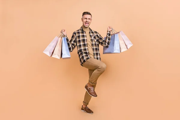 Pełne ciało zdjęcie dojrzałego wesoły człowiek zadowolony sklep trzymać pakiet izolowane nad beżowym tle kolor — Zdjęcie stockowe