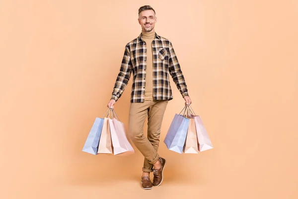 フルサイズ写真の成熟した男性ホールドショッピングバッグ店ブティック割引隔離上ベージュ色背景 — ストック写真