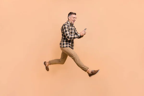 Полный размер профиля стороне фото взволнованный человек типа смс мобильного телефона прыжок шаг комментарий пост спешить изолированы на бежевом фоне цвета — стоковое фото