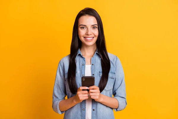 Retrato de bom otimista morena senhora tipo telefone desgaste camisa azul isolado no fundo de cor amarelo brilhante — Fotografia de Stock