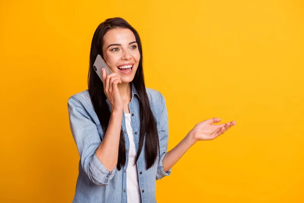 Portret de frumos optimist bruneta doamnă vorbesc telefon purta cămașă albastră izolat pe fundal de culoare galben strălucitor — Fotografie, imagine de stoc