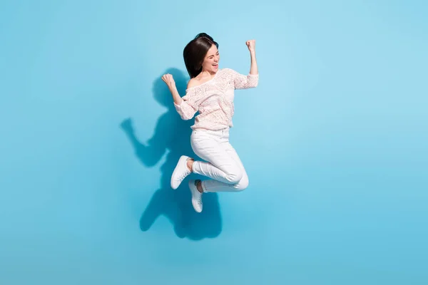 Full storlek foto av upphetsad galen glad dam hoppa upp luft gott humör vinnare isolerad på blå färg bakgrund — Stockfoto
