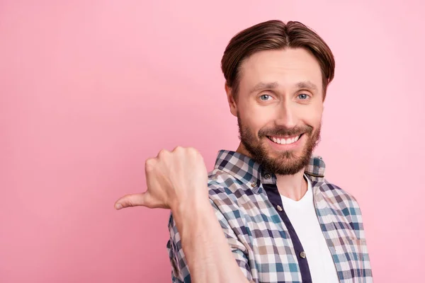 Фото молодого веселого человека счастливая положительная улыбка точка большой палец пустое пространство объявление предложить продажу изолированы на розовый цвет фона — стоковое фото