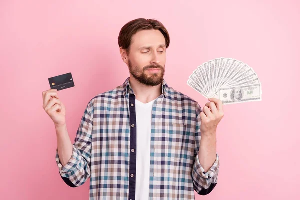 Foto van jonge man gelukkig positieve glimlach kijken valuta credit card inkomen geïsoleerd over roze kleur achtergrond — Stockfoto
