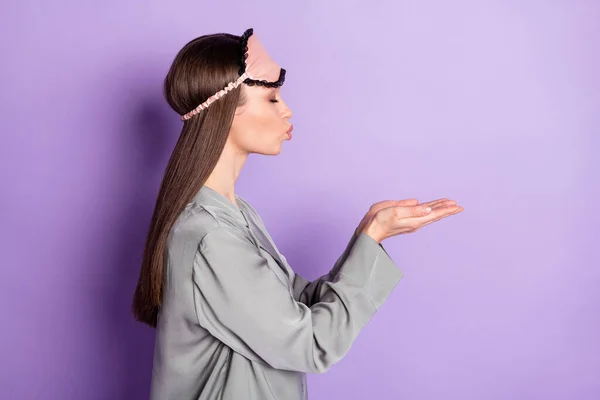 Profil côté photo de flirt belle jeune femme envoyer de l'air baiser mains vide espace porter pyjama isolé sur fond de couleur violette — Photo