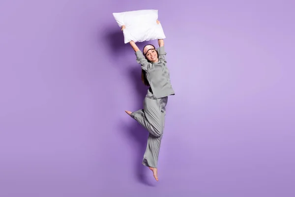 Tamanho total do corpo foto de menina saltando com travesseiro branco no pijama partido isolado pastel cor violeta fundo — Fotografia de Stock