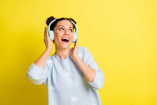 Foto van dame luisteren muziek kijken lege ruimte open mond dragen oortjes blauw pullover geïsoleerde gele achtergrond — Stockfoto