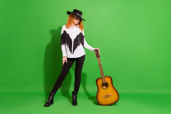 Volledige lengte lichaam grootte uitzicht van aantrekkelijke ernstige meisje poseren holding gitaar geïsoleerd over helder groene kleur achtergrond — Stockfoto