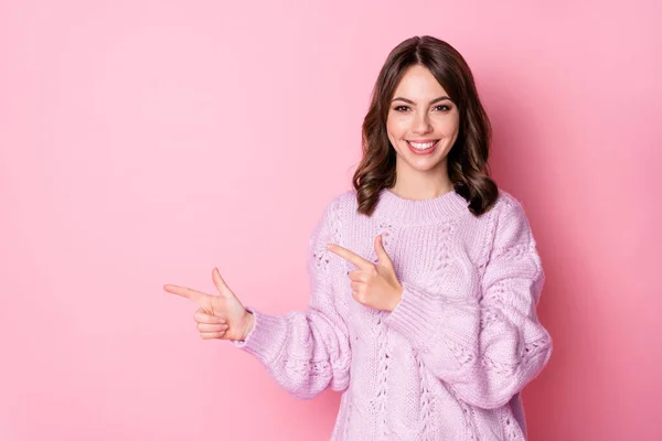Retrato de atractiva chica de pelo ondulado alegre demostrando copia espacio vacío lugar en blanco aislado sobre fondo de color pastel rosa —  Fotos de Stock