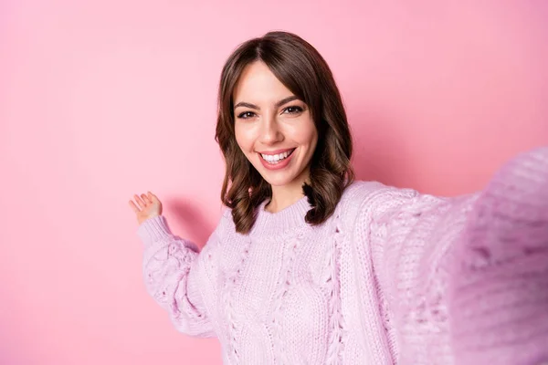 Foto de alegre niña positiva mostrar la mano espacio vacío desgaste jersey de punto aislado de color rosa fondo —  Fotos de Stock
