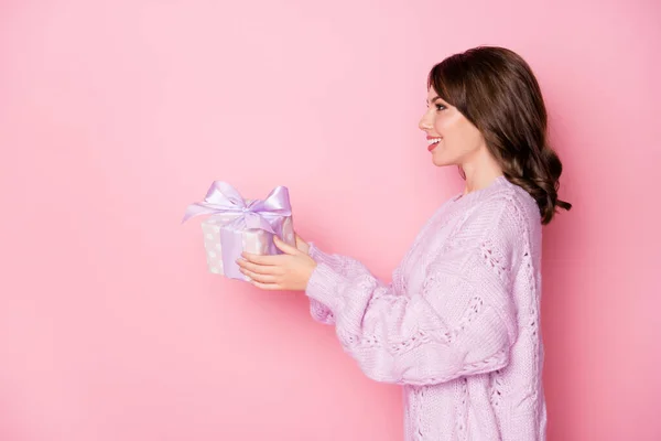 Perfil vista lateral retrato de encantadora chica alegre sosteniendo en las manos dando caja de regalo aislado sobre fondo de color azul pastel rosa —  Fotos de Stock
