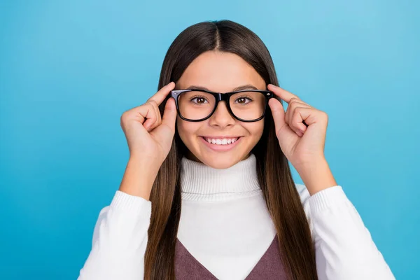 Foto av ganska smart student flicka bära brun klänning armar glasögon ler isolerad blå färg bakgrund — Stockfoto