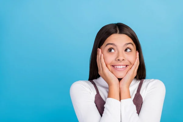 Foto de estudante sonhador pensativo menina usar vestido marrom sorrindo olhando vazio espaço braços bochechas isolado azul cor fundo — Fotografia de Stock