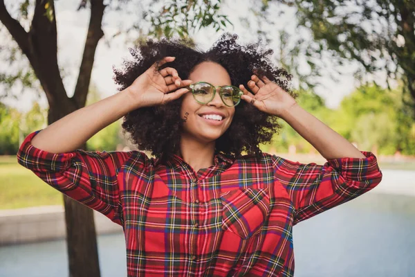 Foto porträtt kvinna promenader i staden bär snygga glasögon rutig skjorta ler glad på sommaren — Stockfoto