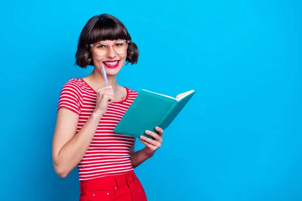 Foto Porträt Mädchen in Brille lächelnd Schreiben Notizen im Tagebuch isoliert lebendige blaue Farbe Hintergrund suchen Kopierraum — Stockfoto
