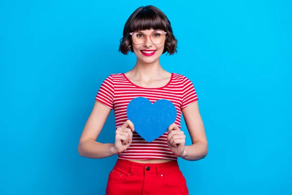 Foto retrato menina em óculos smiing mostrando coração isolado vívido azul cor de fundo — Fotografia de Stock