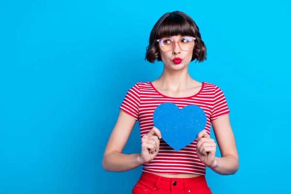 Foto retrato menina em óculos olhando copyspace pouted lábios mostrando coração isolado vívido azul cor de fundo — Fotografia de Stock