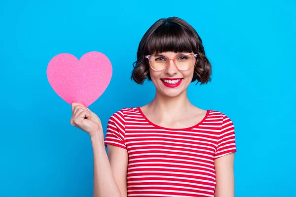 Foto retrato menina em óculos mostrando papel coração isolado vívido azul cor de fundo — Fotografia de Stock