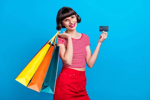 Foto retrato menina sorrindo mantendo sacos após venda cartão de crédito isolado vibrante azul cor fundo — Fotografia de Stock
