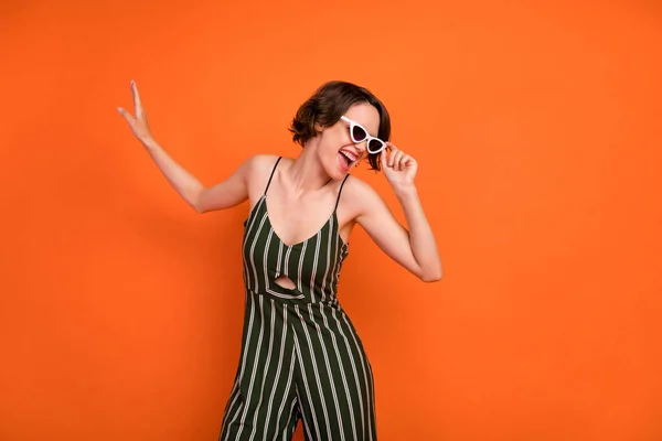 Foto av ung attraktiv flicka glad positiv leende hand touch glasögon isolerade över orange färg bakgrund — Stockfoto
