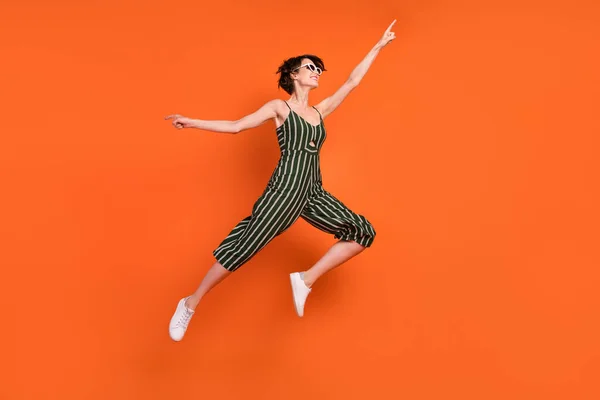 Teljes test profil oldal fotó fiatal lány boldog pozitív mosoly ugrik fel energikus elszigetelt felett narancs színű háttér — Stock Fotó